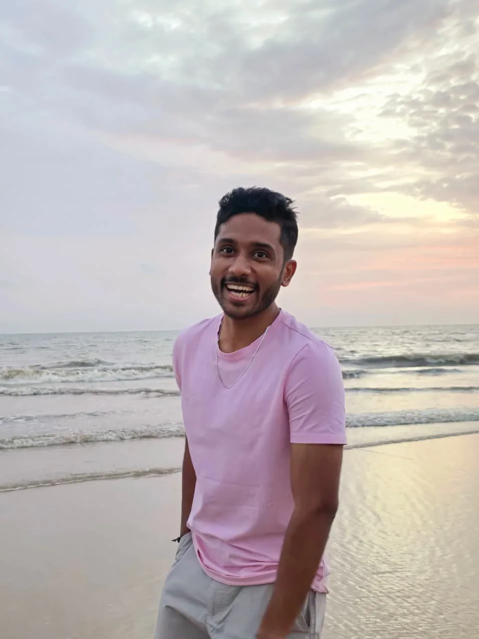 Kamal Deep smiling on a beach at sunset